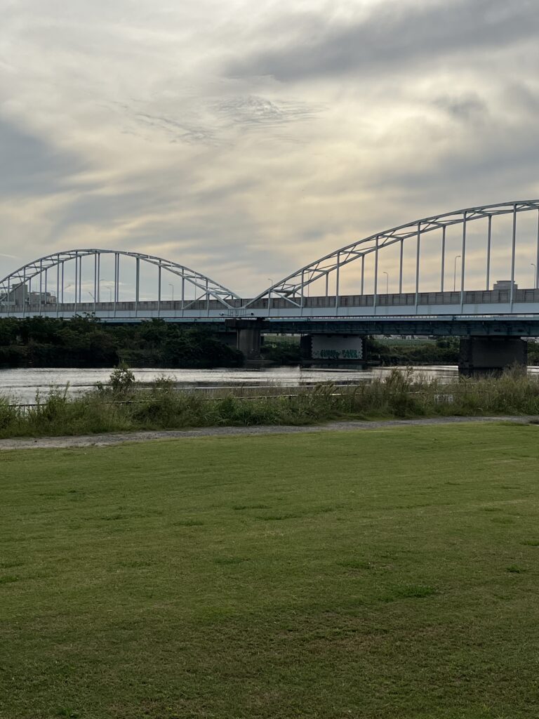 芝生の向こうに広がる多摩川大橋。長い旅の終わりに見えた穏やかな午後の光。