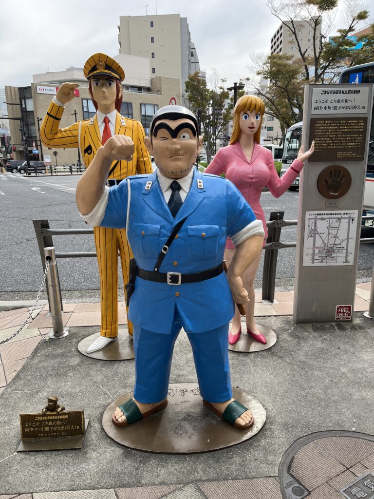 亀有駅前に並ぶキャラクター像。両さん、中川、麗子の3人が訪れる人を出迎える。