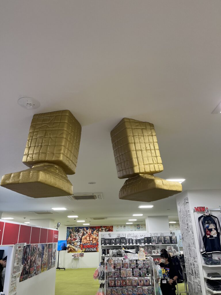 キン肉マンミュージアムの展示室。天井から突き出す黄金の巨大なサンシャインの足が印象的なインテリア演出。